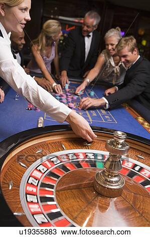 Group of people in casino playing roulette and smiling (selective focus) View Large Photo Image Stock Image - Group of people in casino playing roulette and smiling (selective focus). Fotosearch