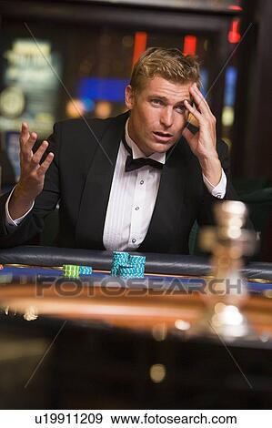 Man in casino playing roulette and losing (selective focus) View Large Photo Image Stock Photo - Man in casino playing roulette and losing (selective focus). Fotosearch