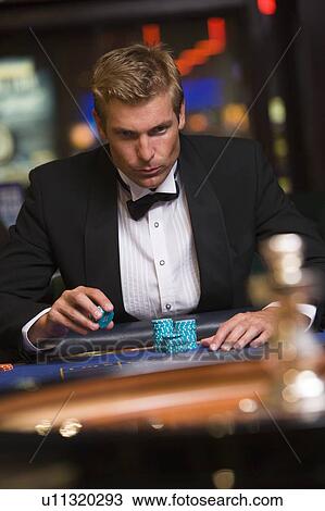 Stock Image - Man in casino playing roulette (selective focus). Fotosearch