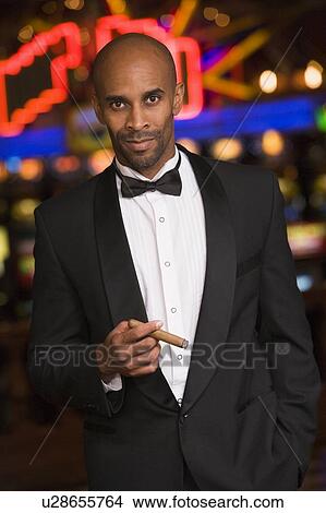 Man in casino smoking cigar (selective focus) View Large Photo Image Picture - Man in casino smoking cigar (selective focus). Fotosearch