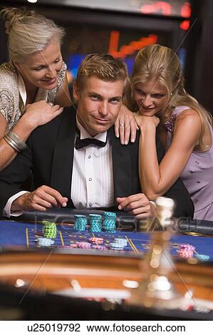 Three people in casino playing roulette smiling (selective focus) View Large Photo Image Stock Image - Three people in casino playing roulette smiling (selective focus). Fotosearch