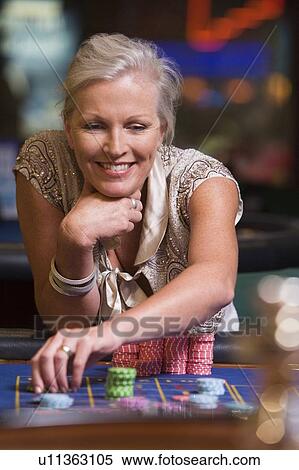 Woman in casino playing roulette and smiling (selective focus) View Large Photo Image Stock Photography - Woman in casino playing roulette and smiling (selective focus). Fotosearch