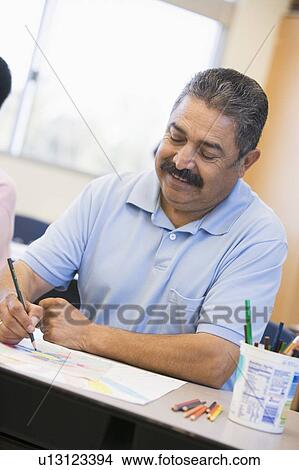 Picture - Adult student in class taking notes. Fotosearch