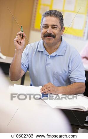 Adult student in class volunteering for teacher (selective focus) View Large Photo Image Stock Image - Adult student in class volunteering for teacher (selective focus). Fotosearch