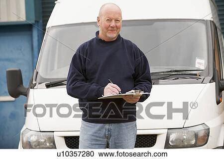 Deliveryperson standing with van writing in clipboard View Large Photo Image Stock Image - Deliveryperson standing with van writing in clipboard. Fotosearch