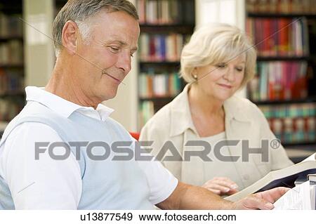Man and woman in library reading (selective focus) View Large Photo Image Stock Photo - Man and woman in library reading (selective focus). Fotosearch