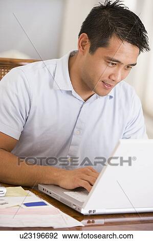Man in dining room using laptop View Large Photo Image Stock Image - Man in dining room using laptop. Fotosearch