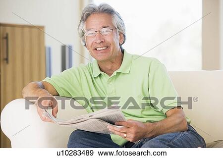 Stock Photo - Man relaxing with a newspaper smiling. Fotosearch