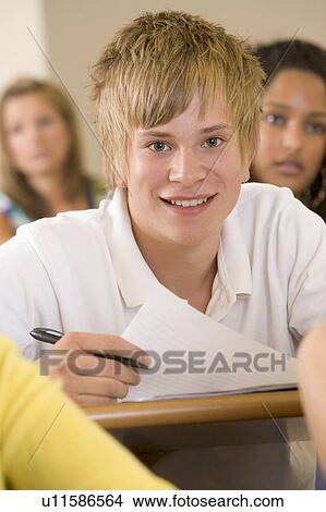 Picture - Student in class taking notes (selective focus). Fotosearch
