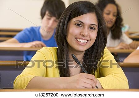 Stock Image - Student in class taking notes (selective focus). Fotosearch