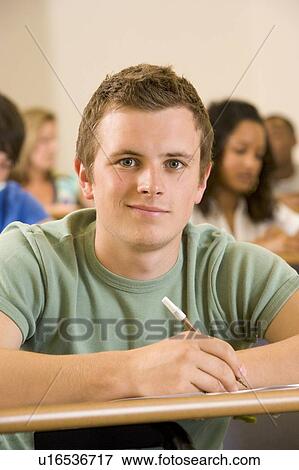 Stock Photo - Student in class taking notes (selective focus). Fotosearch