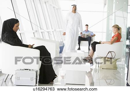 Stock Image - Airline passengers waiting in departure gate. Fotosearch