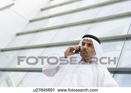 Businessman standing outdoors by building on cellular phone (selective focus) View Large Photo Image Stock Image - Businessman standing outdoors by building on cellular phone (selective focus). Fotosearch