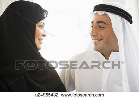 Couple indoors facing each other smiling (high key) View Large Photo Image Stock Image - Couple indoors facing each other smiling (high key). Fotosearch