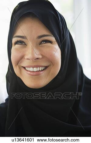 Woman standing indoors smiling (high key) View Large Photo Image Stock Image - Woman standing indoors smiling (high key). Fotosearch