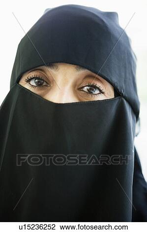 Stock Image - Woman wearing black veil indoors (high key). Fotosearch