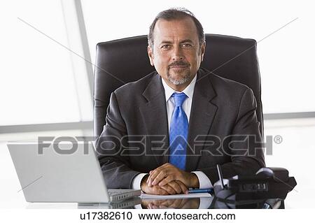 Businessman in office with laptop (high key/selective focus) View Large Photo Image Stock Image - Businessman in office with laptop (high key/selective focus). Fotosearch