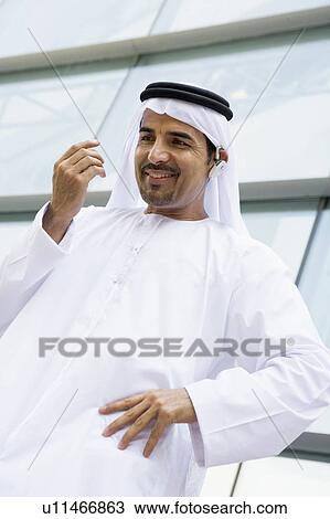 Businessman outdoors by building wearing headset and smiling View Large Photo Image Stock Image - Businessman outdoors by building wearing headset and smiling. Fotosearch