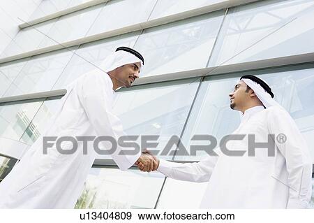 Two businessmen outdoors by building shaking hands View Large Photo Image Stock Photo - Two businessmen outdoors by building shaking hands. Fotosearch