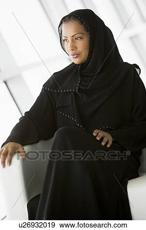 Woman sitting indoors (high key/selective focus) View Large Photo Image Stock Photo - Woman sitting indoors (high key/selective focus). Fotosearch
