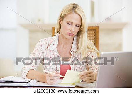 Woman in dining room with laptop smiling View Large Photo Image Stock Image - Woman in dining room with laptop smiling. Fotosearch