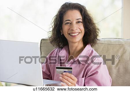 Woman with a laptop computer making an online purchase with credit card View Large Photo Image Stock Image - Woman with a laptop computer making an online purchase with credit card. Fotosearch
