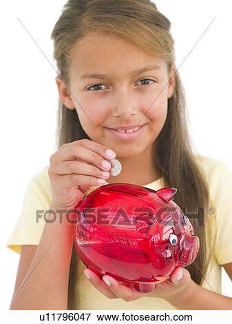 Young girl putting coin into piggy bank smiling View Large Photo Image Stock Photo - Young girl putting coin into piggy bank smiling. Fotosearch