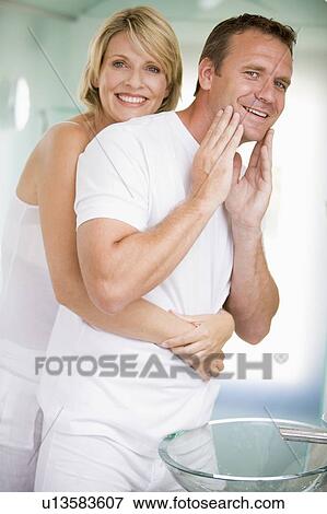Stock Photo - Couple in bathroom embracing and smiling. Fotosearch