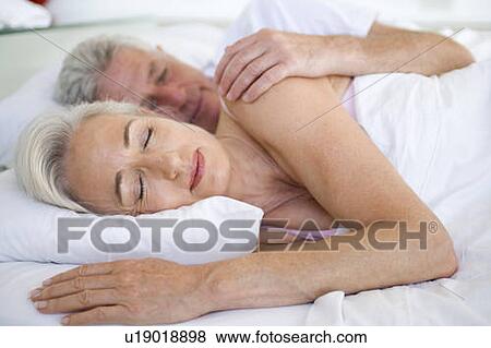 Couple lying in bed together sleeping View Large Photo Image Stock Photo - Couple lying in bed together sleeping. Fotosearch