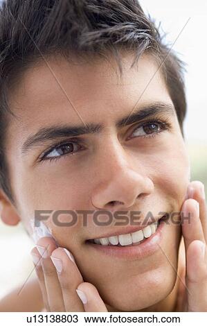 Stock Image - Man applying shaving cream smiling. Fotosearch