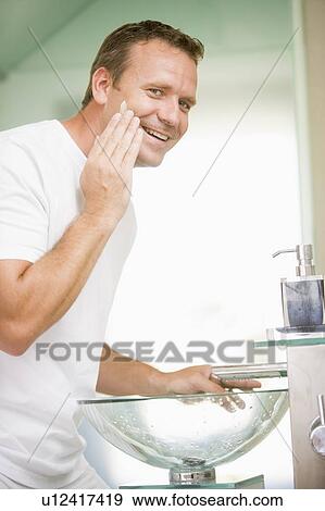 Man in bathroom applying shaving cream and smiling View Large Photo Image Stock Photo - Man in bathroom applying shaving cream and smiling. Fotosearch