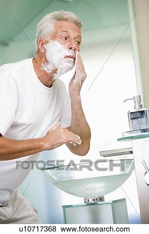 Stock Photo - Man in bathroom shaving. Fotosearch