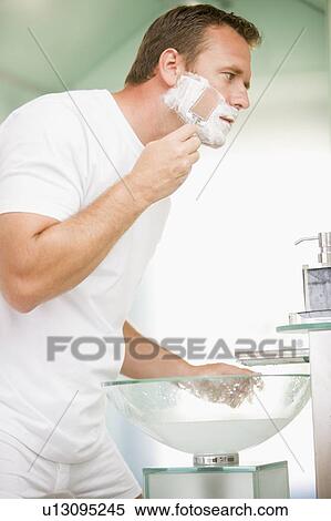 Stock Photography - Man in bathroom shaving. Fotosearch