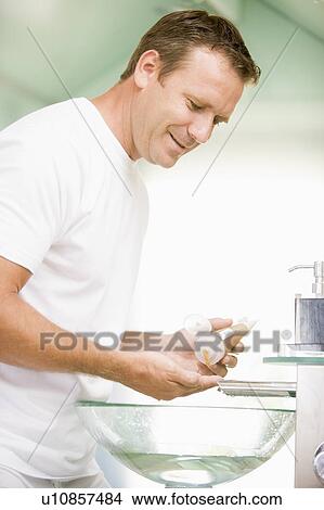 Man in bathroom with hair gel smiling View Large Photo Image Picture - Man in bathroom with hair gel smiling. Fotosearch
