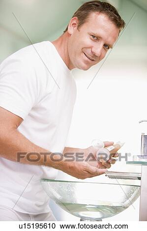 Man in bathroom with hair gel smiling View Large Photo Image Stock Image - Man in bathroom with hair gel smiling. Fotosearch