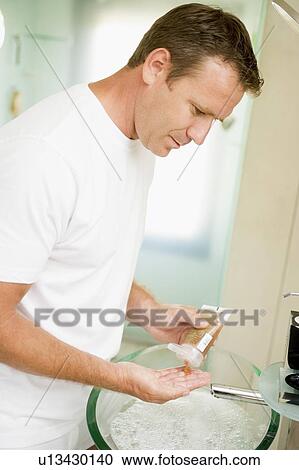 Man in bathroom with hair gel View Large Photo Image Stock Image - Man in bathroom with hair gel. Fotosearch
