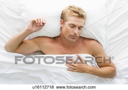 Man lying in bed sleeping View Large Photo Image Stock Photo - Man lying in bed sleeping. Fotosearch
