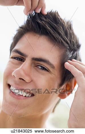 Stock Photography - Man playing with hair smiling. Fotosearch