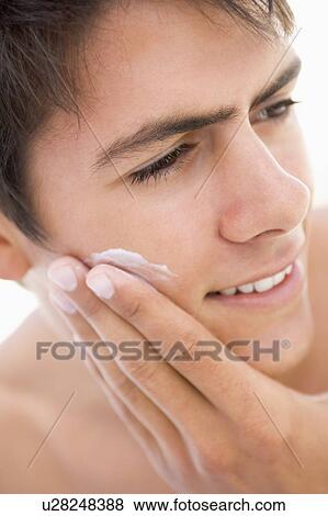 Stock Photo - Man putting on shaving cream smiling. Fotosearch
