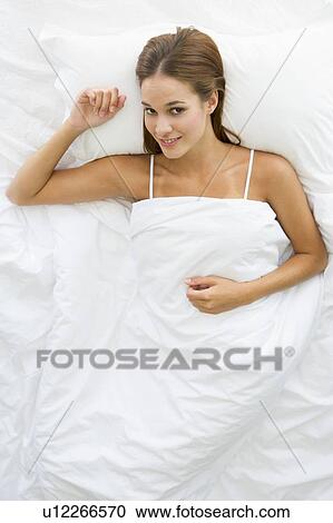 Woman lying in bed relaxing View Large Photo Image Stock Image - Woman lying in bed relaxing. Fotosearch