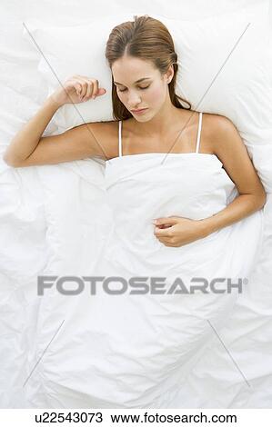 Woman lying in bed sleeping View Large Photo Image Stock Image - Woman lying in bed sleeping. Fotosearch