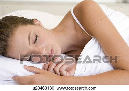 Woman lying in bed sleeping View Large Photo Image Stock Image - Woman lying in bed sleeping. Fotosearch
