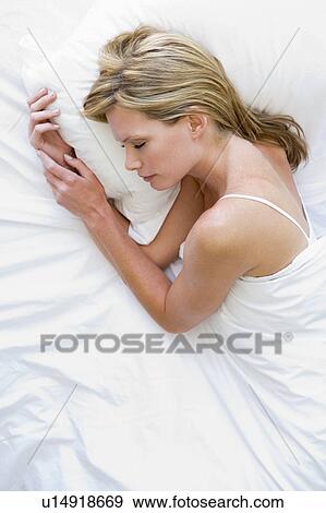 Stock Photo - Woman lying in bed sleeping. Fotosearch