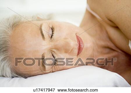 Stock Photo - Woman lying in bed sleeping. Fotosearch