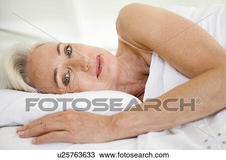 Woman lying in bed smiling View Large Photo Image Stock Image - Woman lying in bed smiling. Fotosearch