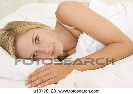Stock Photo - Woman lying in bed. Fotosearch