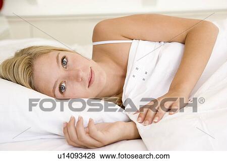 Woman lying in bed View Large Photo Image Stock Photo - Woman lying in bed. Fotosearch
