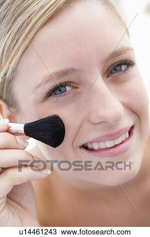Woman with makeup brush smiling View Large Photo Image Stock Image - Woman with makeup brush smiling. Fotosearch