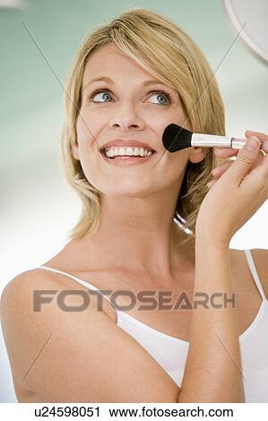 Woman with makeup brush smiling View Large Photo Image Stock Image - Woman with makeup brush smiling. Fotosearch