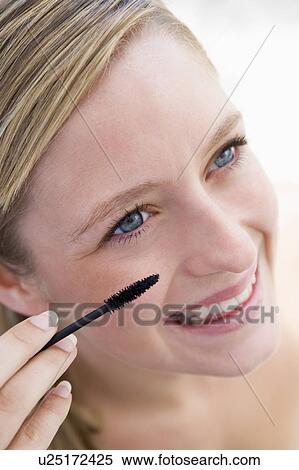 Woman with mascara wand smiling View Large Photo Image Stock Photography - Woman with mascara wand smiling. Fotosearch